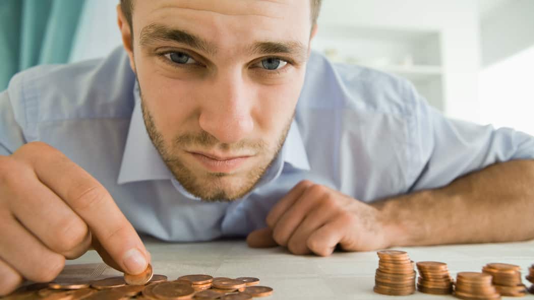 Wie viel Sozialhilfe steht mir zu? Mann sortiert Kleingeld.