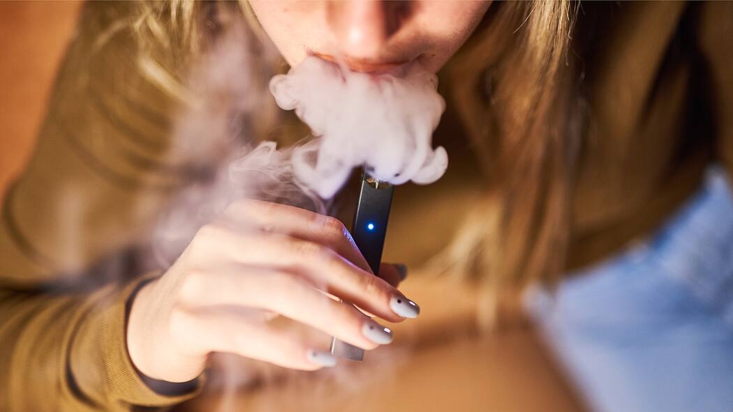 «Mit den neuen E-Zigaretten wird man schneller süchtig» Frau dampft eine Juul-E-Zigarette