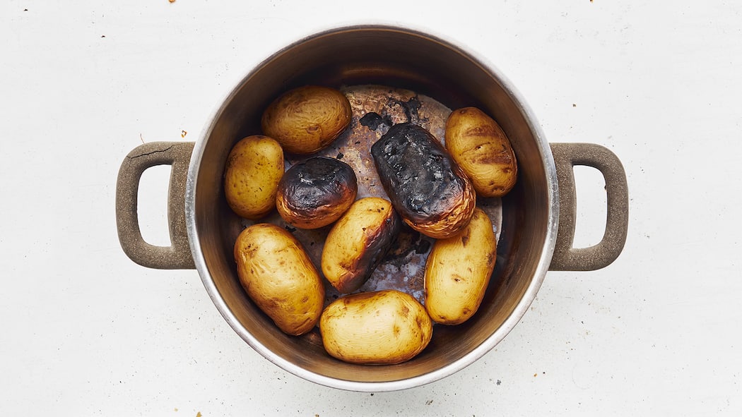 Ganz und gar ungeniessbar Eine Pfanne mit verbrannten Kartoffeln.