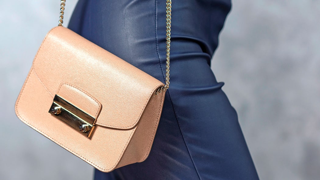 Im Web gekauft – was kann ich tun? Eine Frau trägt eine kleine beige Handtasche mit sich.