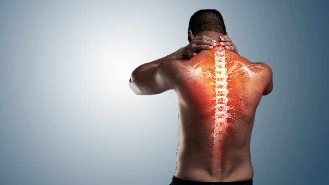 Der richtige Umgang mit Rückenschmerzen Ein Mann hält sich den Nacken. Auf seinen Rücken ist eine Wirbelsäule projiziert.