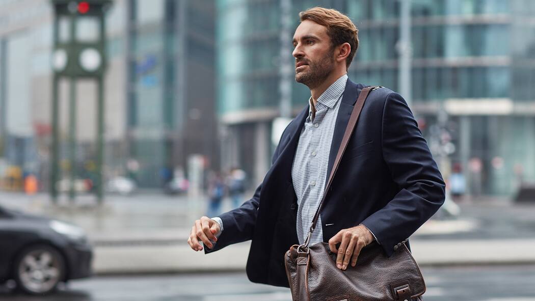 «Stress kann einen Herzinfarkt begünstigen» Ein Mann läuft gehetzt einer Strasse entlang.