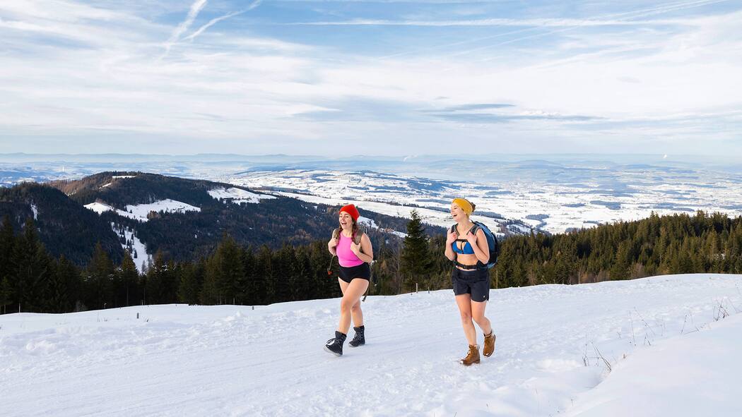 Kälte annehmen, sagt der Kopf 2 Frauen im Schnee in Bikini und Shorts. Kältetrainings sollen besonders gesund sein. Unsere Autorin wollte es genauer wissen und ging in Shorts und Tanktop im Schnee wandern.