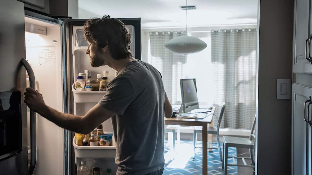 Drei Ernährungstipps für den Lockdown Mann vor Kühlschrank
