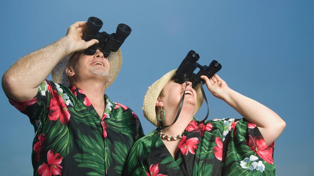 In diesen Punkten gleichen sich Paare an Ein Paar, das sich aufgrund ihres Äusseren sowie der Kleidung sehr ähnlich sieht, steht im Freien und blickt mit einem Feldstecher in die Ferne.