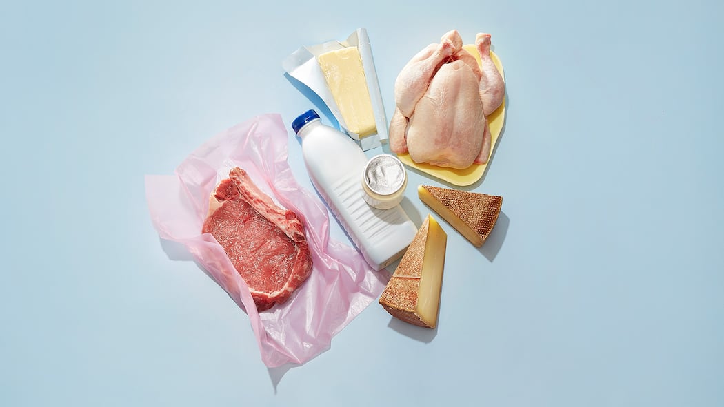 Essen mit gutem Gewissen Rindfleisch sowie diverse Milchprodukte liegen auf einer blauen Oberfläche.