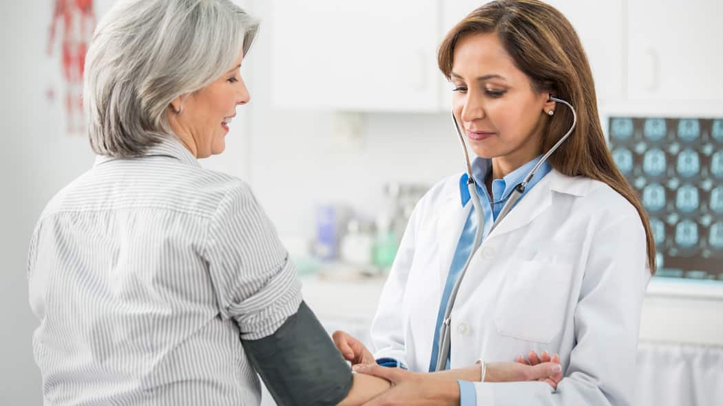 Die wichtigsten Früherkennungstests für Frauen Eine Ärztin untersucht eine ältere Patientin.