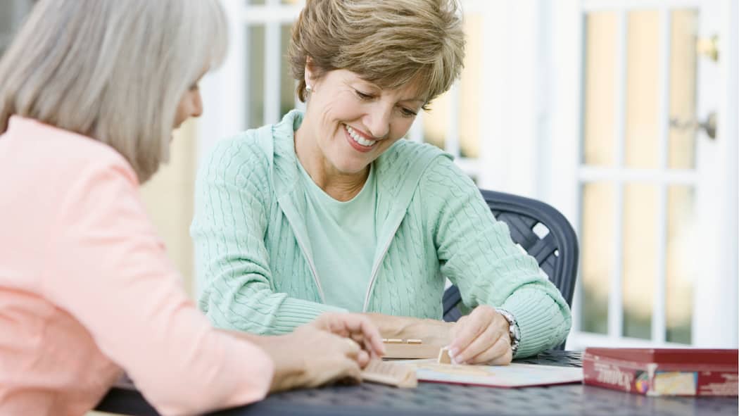 Gymnastik für die grauen Zellen Zwei ältere Frauen spielen Scrabble.