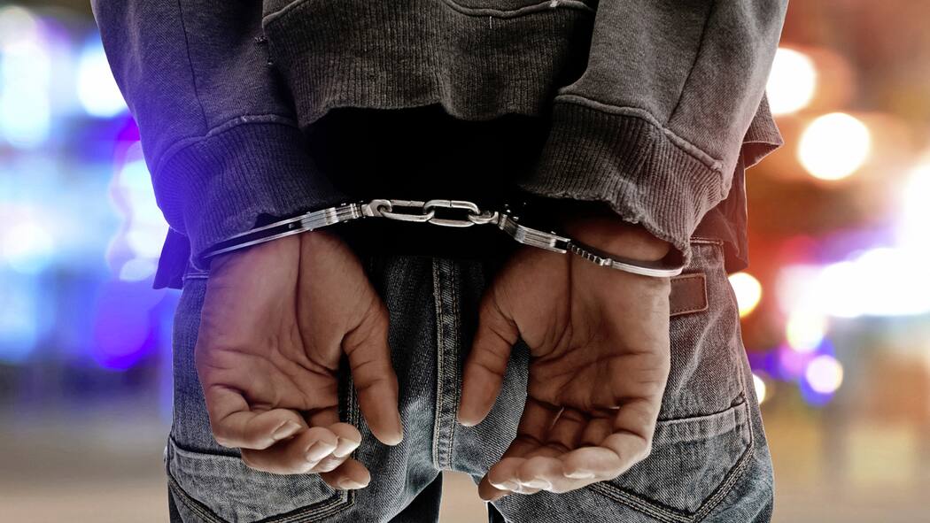 Zwei Tage in Haft, weil Staatsanwaltschaft schlampte Ein Mann steht auf der Strasse, die Hände sind in Handschellen.