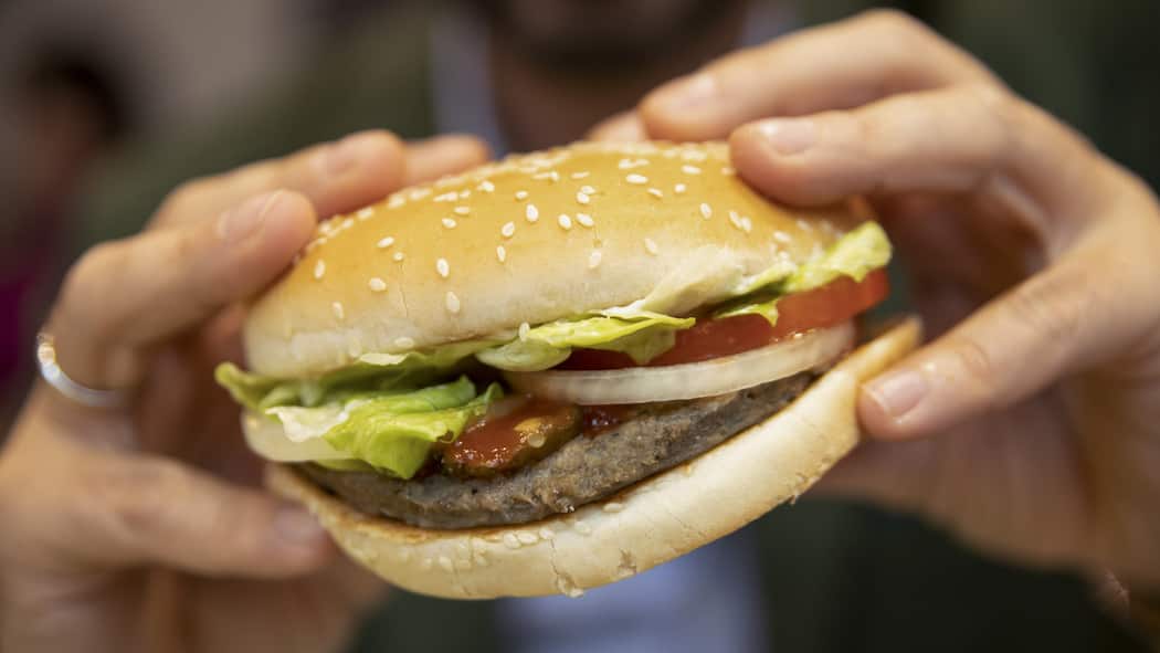 Bei Vegi-Burgern ist die Herkunft wurst Ein Mann isst einen vegetarischen Burger