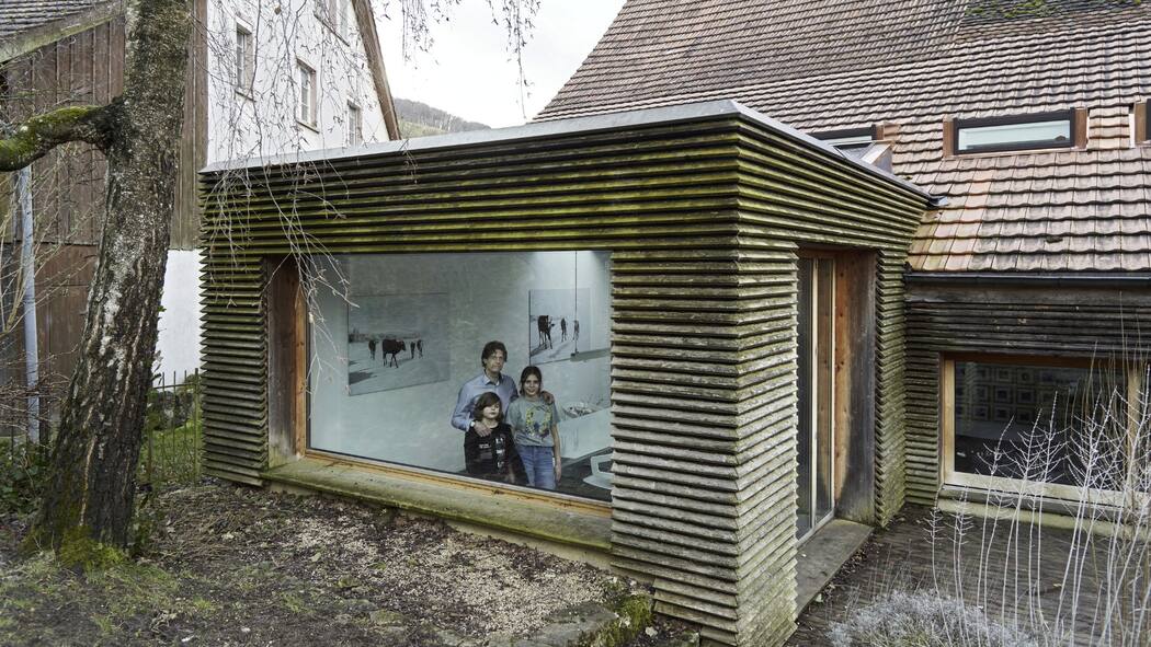 Denkmalschutz muss kein Hindernis sein Architekt Christoph Ecker mit seiner Familie im selbst umgebauten Haus in Oltingen. Blick von aussen durchs Fenster in den Anbau.