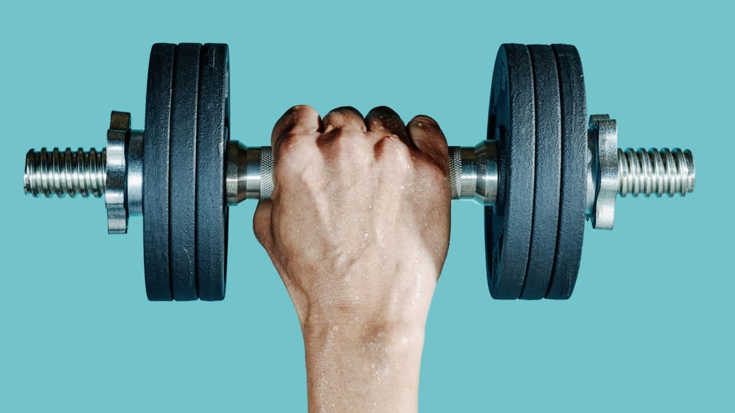 Auch Männer haben ihre Tage Ein Mann hebt mit einer Hand eine kleine Hantel in die Höhe.