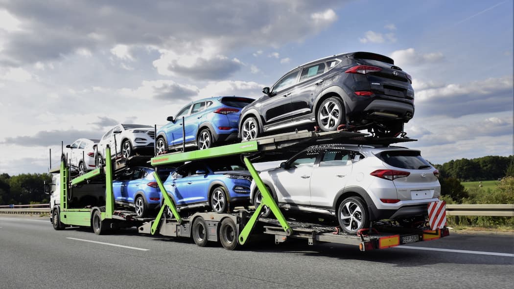 So sparen Sie viel Geld beim Autokauf Ein Autotransport auf einer Strasse