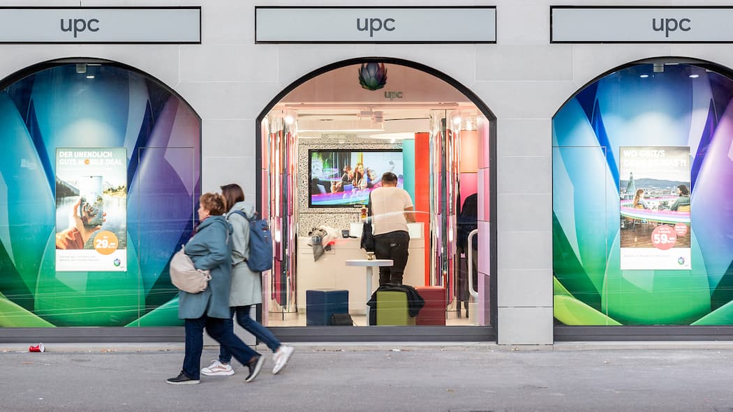 Kündigung nur noch per Chat und Telefon Fensterfront des UPC-Stores am Limmatquai in Zürich, an dem zwei Spaziergängerinnen vorbeigehen.