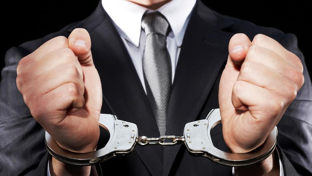 Was für Beschuldigte und Opfer gilt Ein Mann in Anzug trägt Handschellen. Verschaffen Sie sich einen Überblick, wie in der Schweiz ein Strafverfahren generell abläuft.