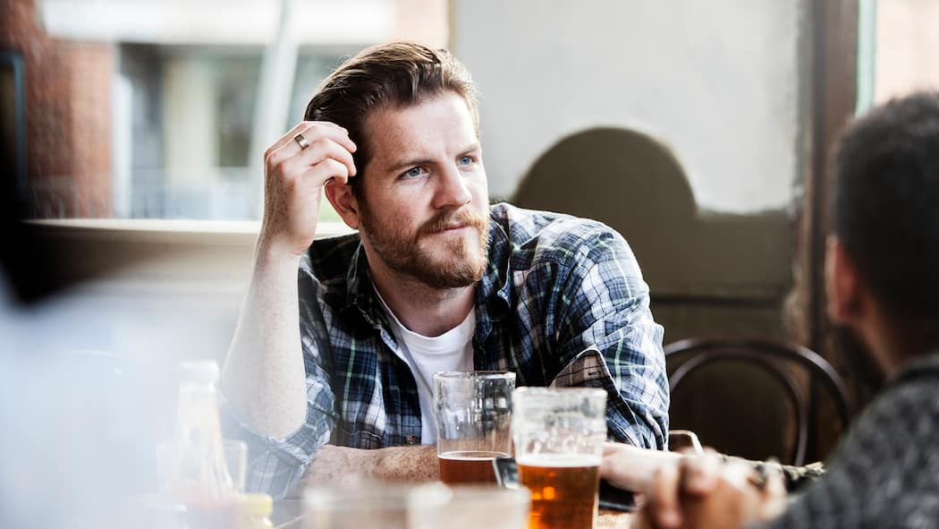 Andere Ansichten – und trotzdem Freunde Ein Mann schaut seinen Freund ungläubig an.