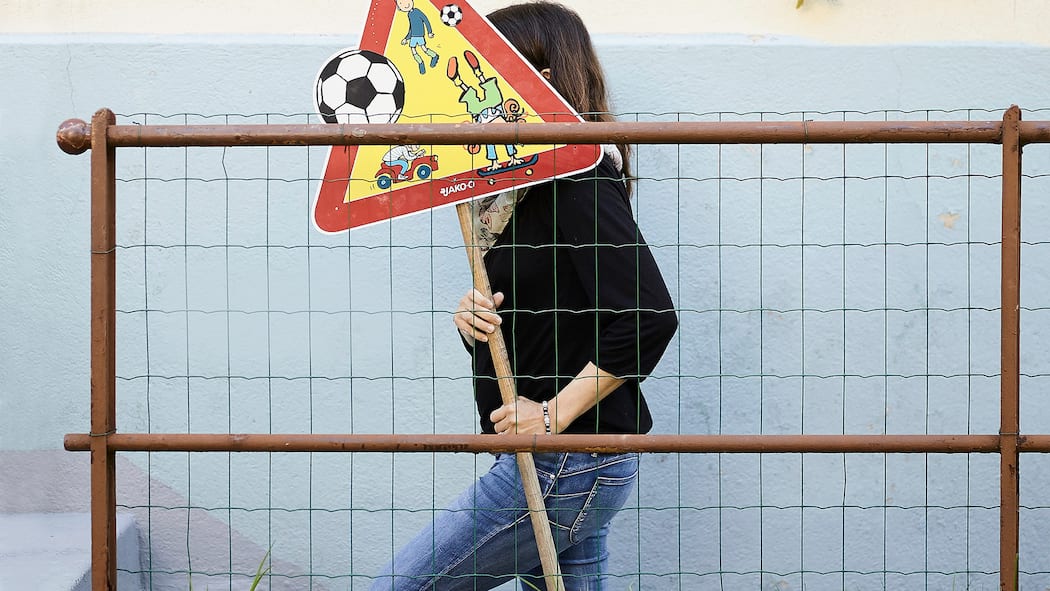 Bei Asbest wird gefährlich geschlampt Frau mit Verkehrsschild