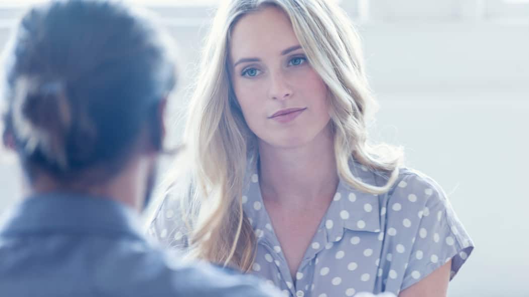 He Chef, bitte keine faulen Ausreden! Eine junge Mitarbeiterin sieht ihren Chef mit resigniertem Blick an während sie in einem Mitarbeitergespräch über den Lohn sprechen.