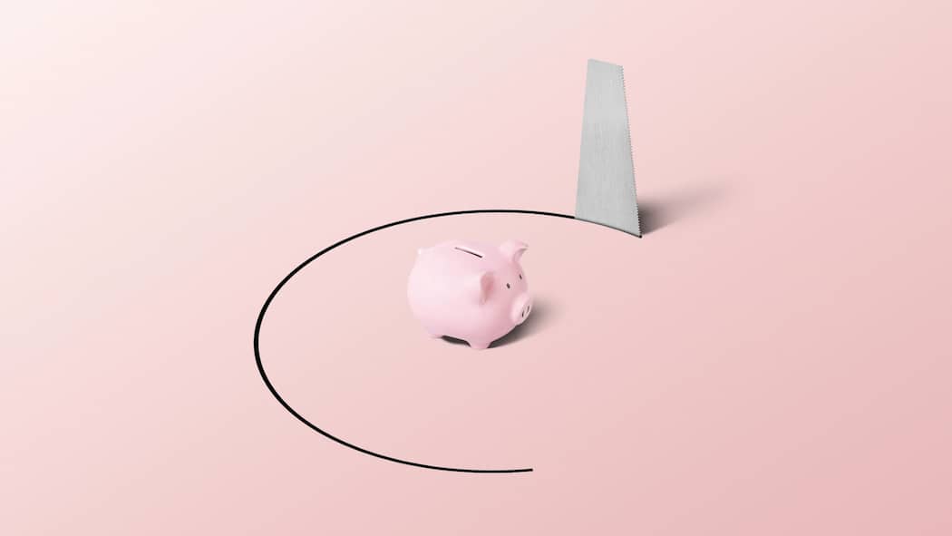 Und plötzlich ist das Geld weg Ein pinkes Sparschwein steht auf einer rosa Oberfläche. Von unten sägt ein Fuchsschwanz das Sparschwein auf einer kreisrunden Fläche aus.