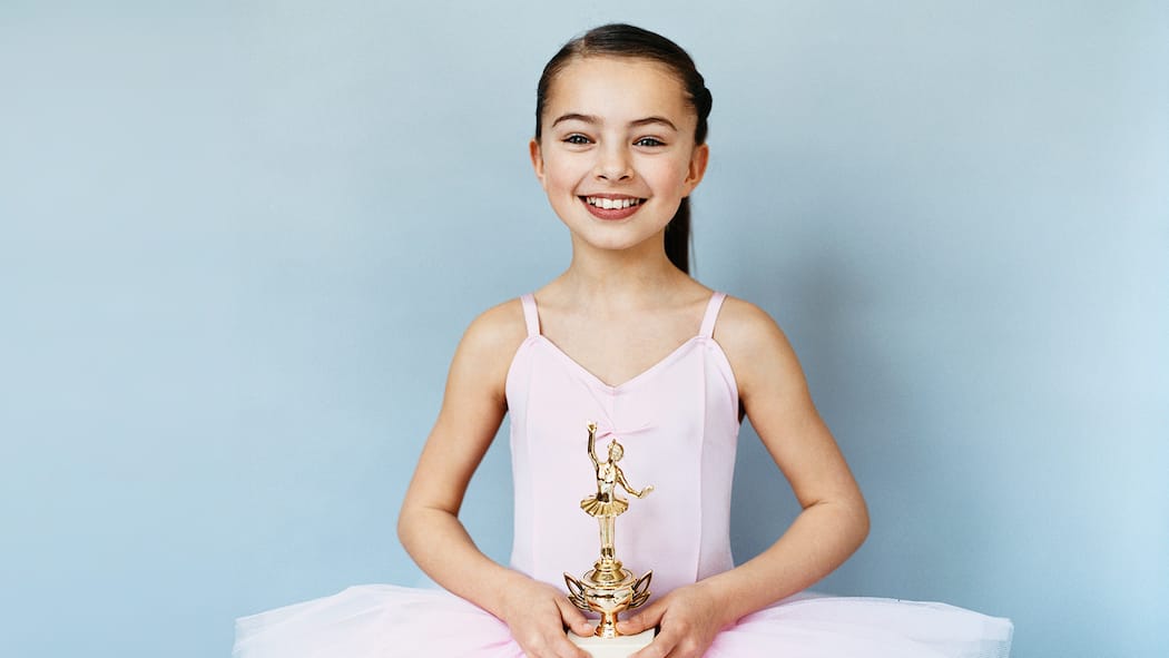 «Es ist ein Ringen um Normalität» Kind in Ballettkleid hält einen Pokal in den Händen