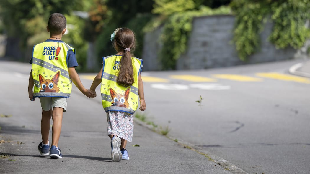 Gefährliche Strassen, fehlende Schulbusse – das können Sie tun Schulkinder der 1. Klasse des Schulhaus Hofmatt in Horw im Kanton Luzern praesentieren ihre neue Leuchtweste auf ihrem Schulweg zum Schulbeginn, anlaesslich einer Medienorientierung zur Lancierung der neuen Leuchtweste fuer die Schueler im Kanton Luz…