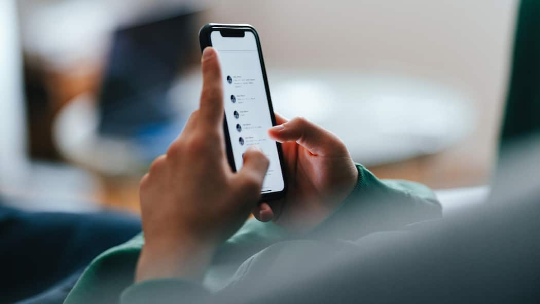 KI-Nacktbilder im Klassenchat – das müssen Eltern wissen Unrecognizable teenage boy typing text messages on his smartphone while lying on a couch at home.
1481613618