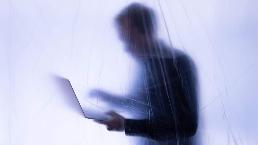 Besonders KMU unterschätzen das Risiko unentdeckter Missstände 2J21B82 Silhoutte eines Büroangestellten steht hinter Plastikfolie mit Laptop