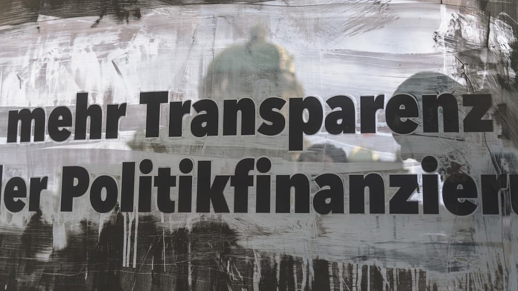 Schlupfloch geschlossen: Bund setzt anonymen Parteispenden ein Ende Mit einer verschmutzte Scheibe wirbt für mehr Transparenz in der Politik geworben.