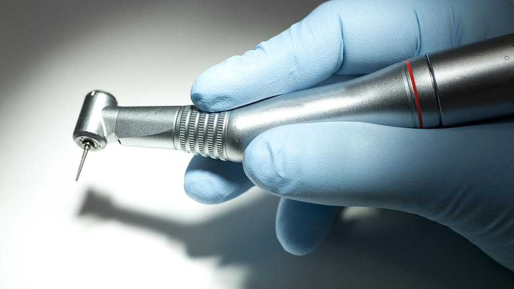 Studierende drohen mit Strafanzeigen gegen Professoren Montage: Zentrum für Zahnmedizin der Universität Zürich und Zahnarzthand mit Bohrer.