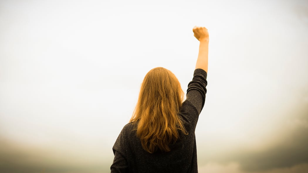 Der Resilienz-Selbsttest Frau reckt kämpferisch die Faust in die Höhe