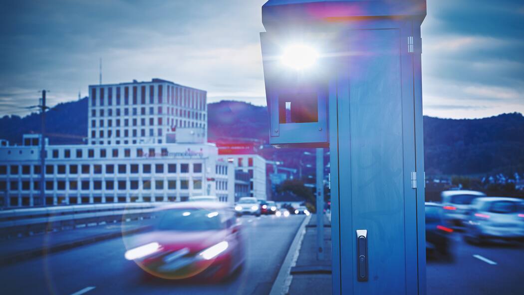 Irrtümer rund um Temposünden Auto rast mit hoher Geschwindigkeit auf der Strasse und wird geblitzt.