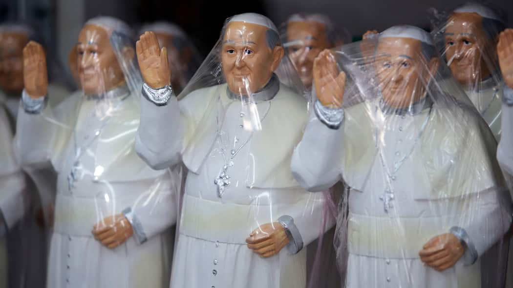 Sie machen Geld mit Austritten aus der Kirche Bild von verpackten Souvenir-Papstfiguren.