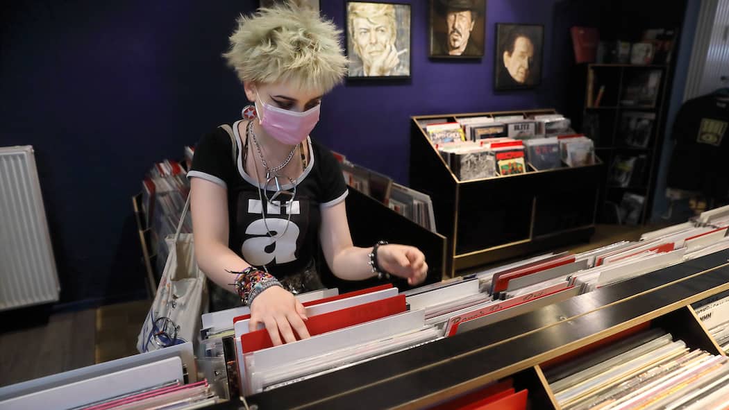 Wer Schallplatten will, muss Monate warten Junge Frau stöbert in Plattenladen
