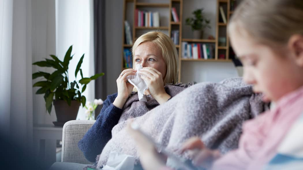 Partner krank – ist Kürzung gerecht? Mutter sitzt krank auf dem Sofa
