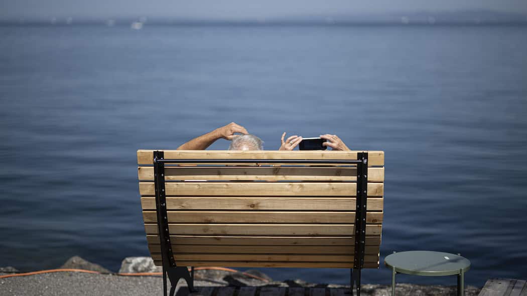 Umbrüche in der Vorsorge – wie Sie sich wappnen Eine Frau macht ein Foto, am Freitag, 18. August 2023, am Bodensee in Rorschach. Die kommenden Tage sollen grossen Teile der Schweiz eine Hitzewelle bringen. (KEYSTONE/Gian Ehrenzeller)