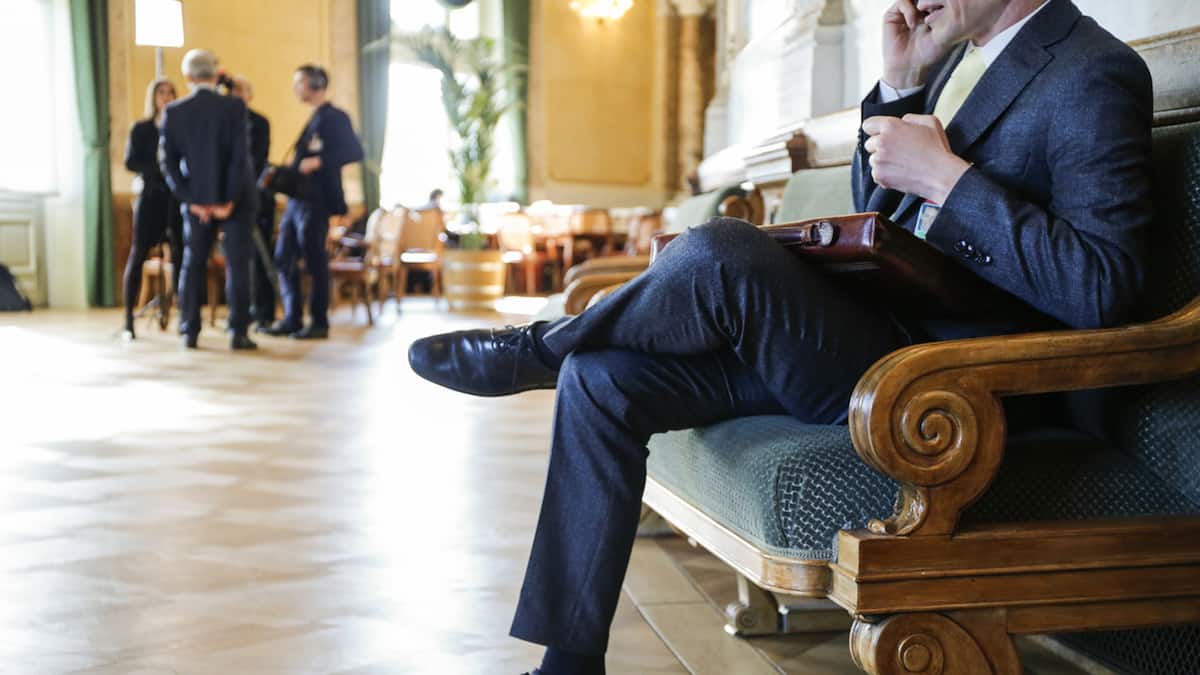 Mann sitzt telefonierend in Wandelhalle