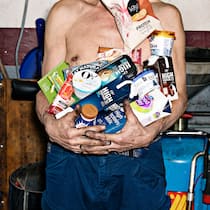 Besessen von Protein Mann hält Lebensmittel, die mit hohem Proteingehalt werben. Eiweisse sind wichtig. Aber Produkte mit extra Protein kosten viel – und sind oft ungesund.