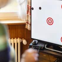 Wie Gamen das Gehirn fit hält Ein Bildschirm mit Kreisen und einer verschwommenen Frau davor. Exergaming soll gegen Demenz vorbeugen.