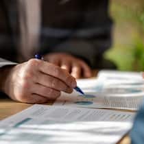 Hochriskante Strategie: Anleger drohen Millionen zu verlieren Close-up photo of a financial adviser's hand with pen showing an investment plan document to clients.
1365021262