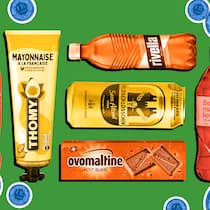 Hält der «Aldi-Preis», was er verspricht? Markenprodukte umgeben von Münzen vor grünem Hintergrund. Warum Markenprodukte bei Discountern nicht billiger sind.