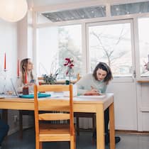 Wie man stressfrei eine Wohngemeinschaft gründet Vier Personen sind zusammen in der Küche.