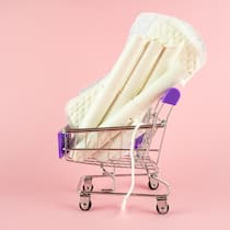 Hier sind Tampons, Binden und Co. am günstigsten Illustration eines Einkaufwagens, gefüllt mit Binden und Tampons. Aldi reduziert nun die Preise für Periodenprodukte.