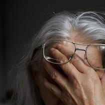 Männer und Frauen stehen gleich schlecht da Eine Seniorin hält sich die Hand vors Gesicht