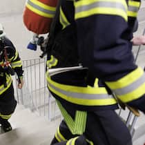 Einfach schnell die Feuerwehr rufen? Mitglieder der freiwilligen Feuerwehr steigen eine Treppe hinauf