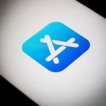 Wann kommen die neuen iPhone-Funktionen in die Schweiz? Das Logo des Apple-Stores wird gross auf einem Smartphone Display gezeigt.