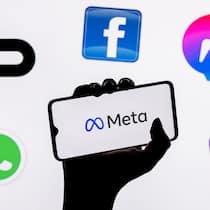 Facebook und Instagram: So schützen Sie jetzt Ihre Daten Eine Hand hält ein Smartphone in die Höhe auf dem «Meta» steht. Rundherum schweben die Logos von Instagram, Whatsapp, Messenger und Facebook.