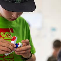 Sie wollen fürs Leben lernen Ein Junge betrachtet ein selbstgebautes Gerät - Lernen ohne Noten und Prüfungen? Das gibt es. Wie ein alternatives Modell einem Bergdorf geholfen hat, die Schule wiederzubeleben