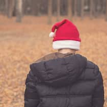 «Man kann sich sehr einsam fühlen, obwohl man von Menschen umgeben ist» Ein Kind ist von hinten fotografiert, mit gesenktem Kopf, auf dem eine Nikolaus-Mütze sitzt.
