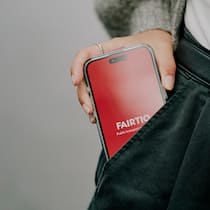 Neues Rabattmodell für ÖV-Nutzer: Das taugt «Premyo» Zu sehen ist ein Smartphone, das bereits halb in der Hosentasche einer Frau verschwindet. Auf dem Bildschirm ist das weisse «Fairtiq»-Logo auf rotem Grund zu sehen.