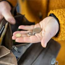 Wer profitiert vom Pensionskassen-Geldsegen? Eine Person zieht waehrend des Marktes auf dem Hevetiaplatz in Zuerich Schweizer Muenze aus ihrem Portemonnaie, fotografiert am Freitag, 16. Februar 2024. (KEYSTONE/Gaetan Bally)